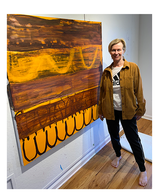 Donna Scarpa standing in front of her painting in her studio